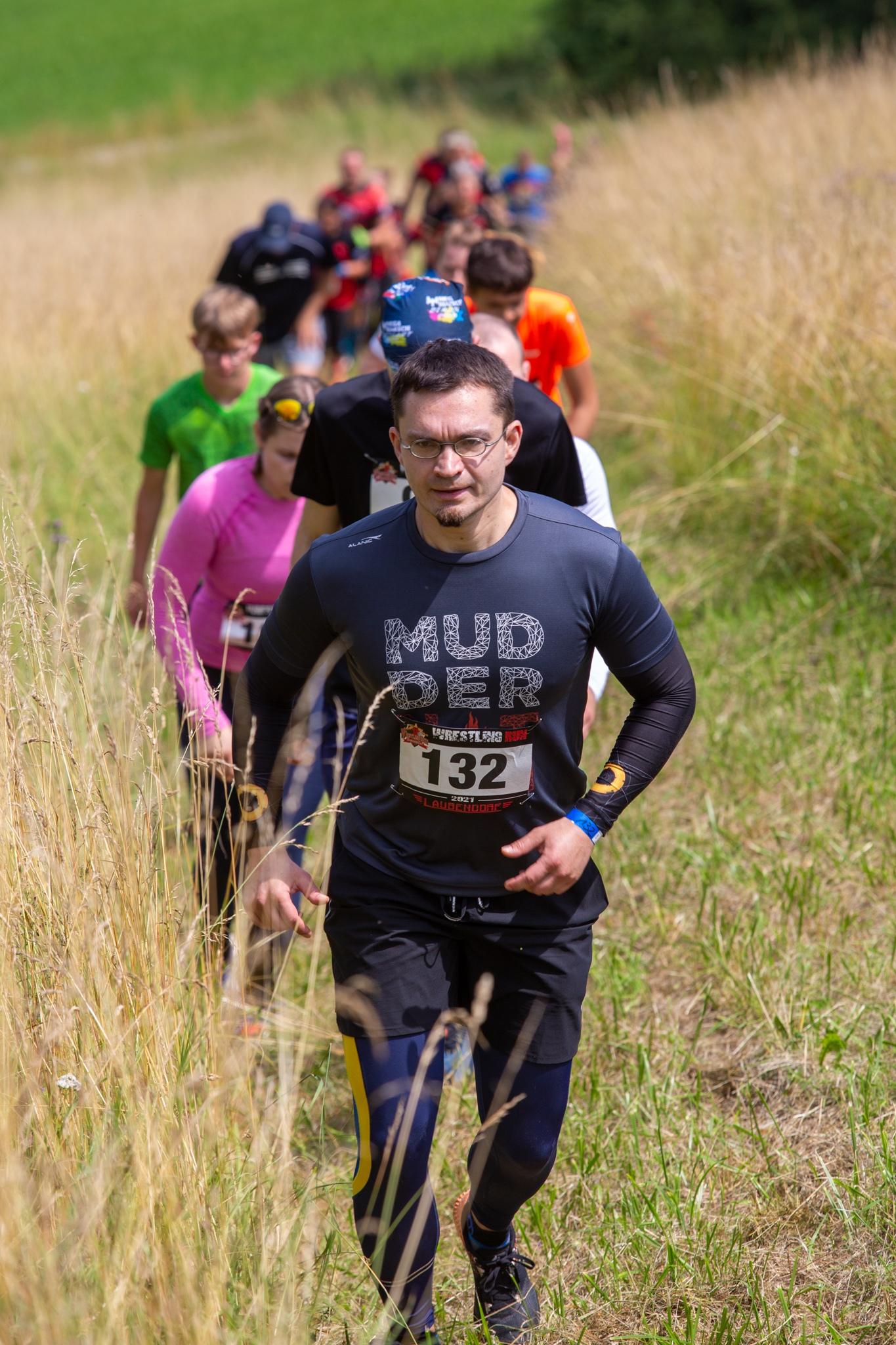 Wie an einer Schnur aufgereiht, laufen die Teilnehmer hintereinander durch die Felder.