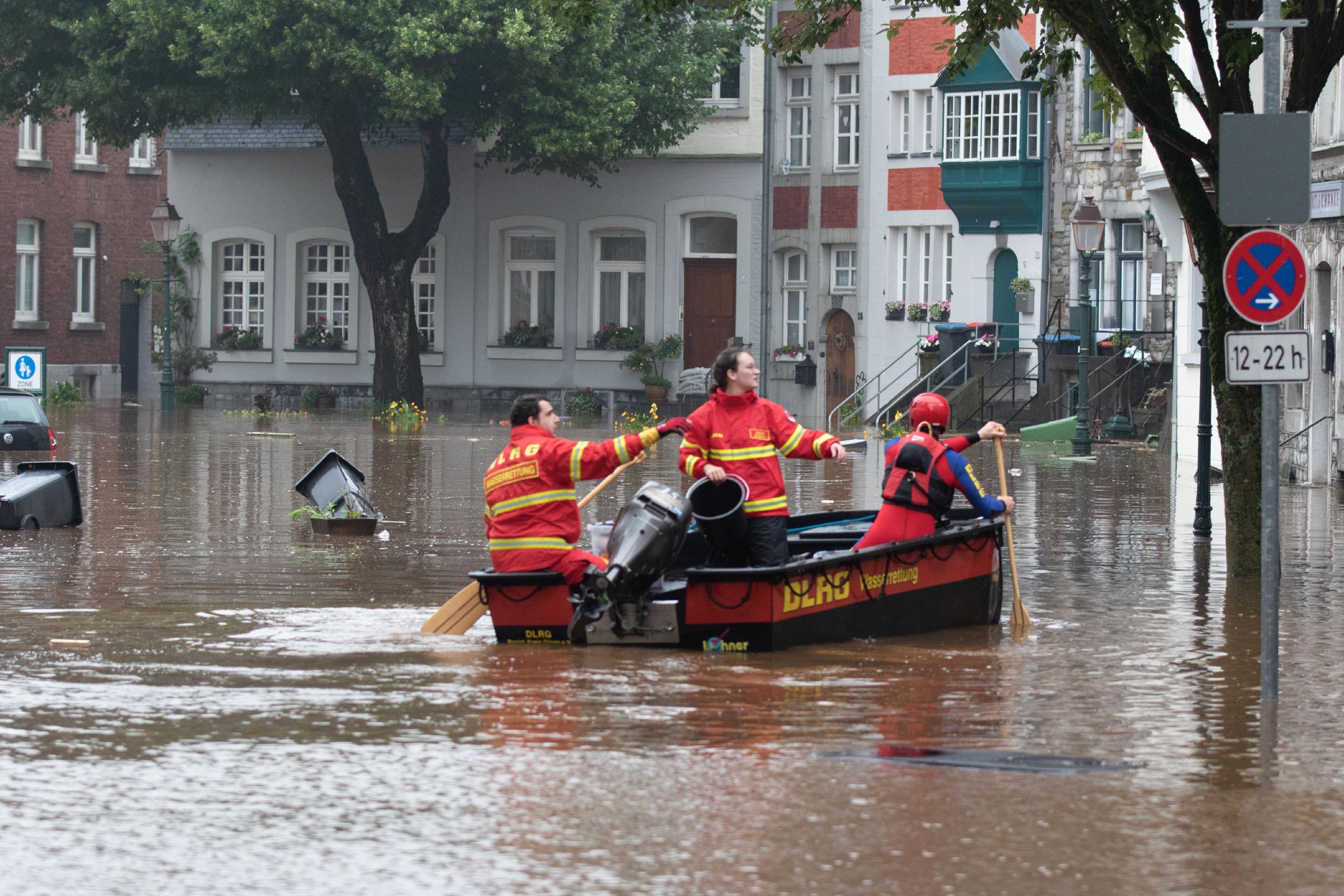 Ein Boot der Deutschen Lebens-Rettungs-Gesellschaft (DLRG) schlängelt sich durch Aachen - einige Straßen stehen komplett unter Wasser.