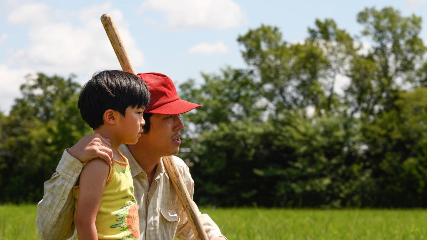 Steven Yeun als Jacob, ein südkoreanischer Einwanderer in den ländlichen USA, mit Alan Kim als dessen Sohn in Steven Yeun als Jacob, ein südkoreanischer Einwanderer in den ländlichen USA, mit Alan Kim als dessen Sohn in