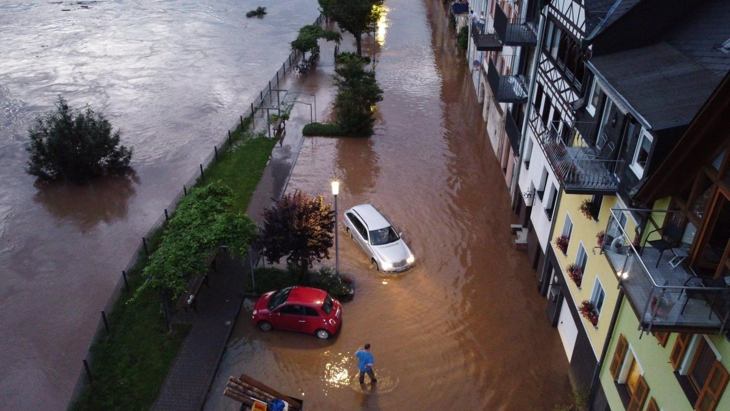 Autos versuchen auf der überfluteten Straße vorwärts zu kommen. Die Mosel ist in der Ortschaft Zell über die Ufer getreten. 