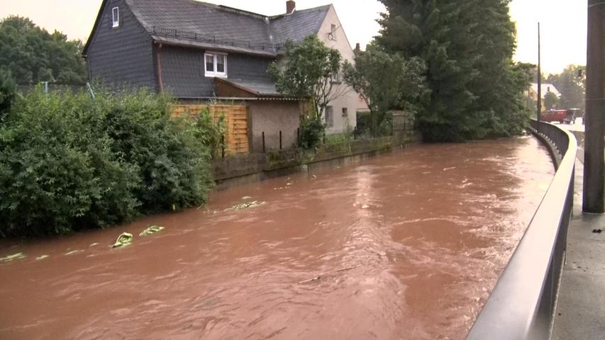 Im sächsischen Oberlungwitz steht nach heftigen Regenfällen eine Straße unter Wasser.