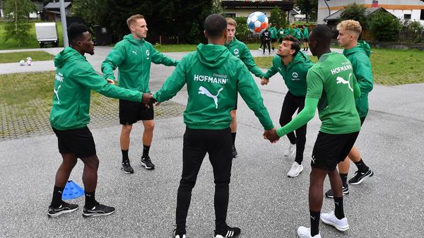 Zuvor mussten die Gruppen sich im Kreis an den Händen fassen und den Ball über eine festgelegte Distanz hinweg hochhalten. Sobald der Ball den Boden berührte, ging es wieder von vorne los.