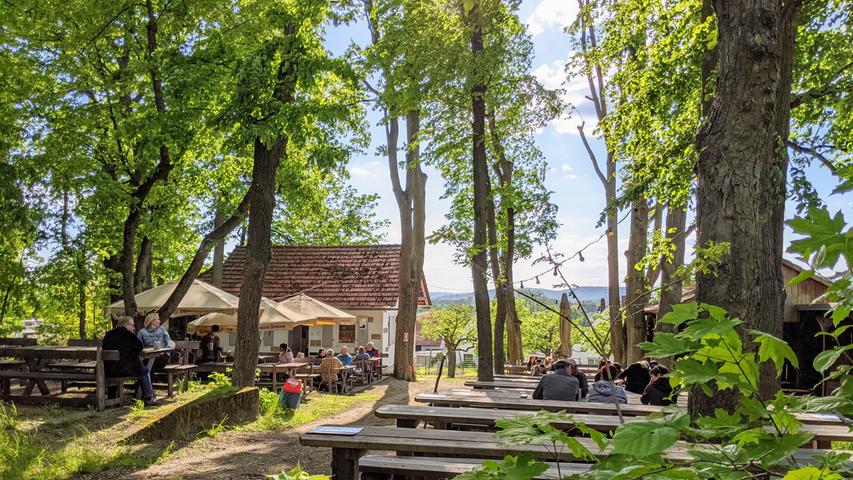 Der Gasthof Höhn ist seit 1783 familiengeführt und befindet sich direkt vor den Toren Bambergs in Memmelsdorf. Bei der Wahl zum schönsten Biergarten der Region 2022 sammelt der Gasthof 50 Stimmen und landet damit auf Platz 8. Selbstgebrautes, naturtrübes Görchla-Bier aus der Braumanufaktur und Brotzeit-Platten sowie verschiedene warme Gerichte wie Schnitzel, Flammkuchen oder Currywurst laden im Hofgarten zum Entspannen ein. "Unsere Küche ist mal fränkisch und bodenständig, mal modern und anspruchsvoll, wobei saisonale Frischprodukte aus Bamberg und der Region verwendet werden", betonen die Betreiber. Der Gasthof hat an allen sieben Wochentagen geöffnet.