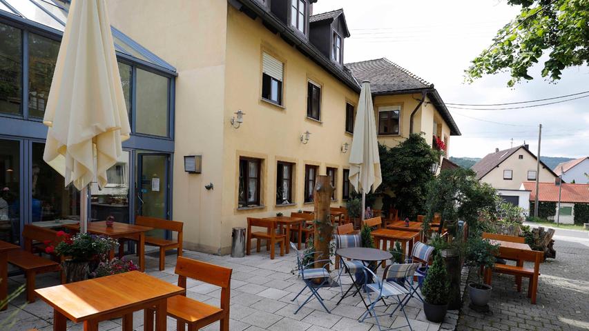 Im Innenhof lädt ein gemütlicher Biergarten mit massiven Holztischen ein. 