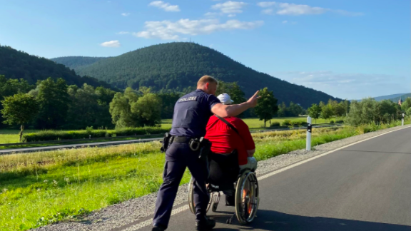 Ein Beamter schiebt den Rollstuhlfahrer zu seinem Freund. Ein Beamter schiebt den Rollstuhlfahrer zu seinem Freund.