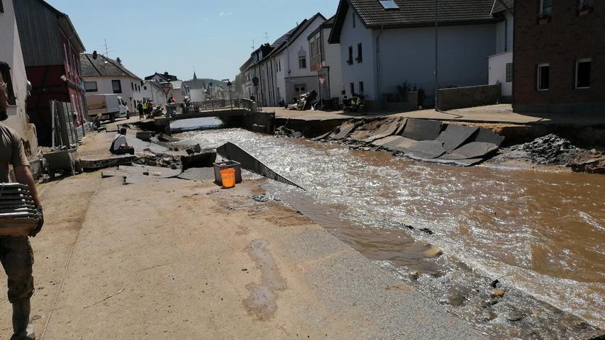Eine zerstörte Straße in der Ortsmitte von Kirspenich: Der Schutt wurde weiter nach unten getragen, da dorthin keine Maschinen zum Abtransport fahren können.