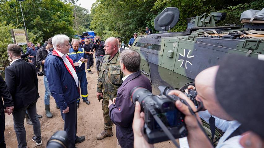 Horst Seehofer unterhält sich mit Kräften der Bundeswehr, die bei der gefährdeten Steinbachtalsperre bei Euskirchen eingesetzt sind.  