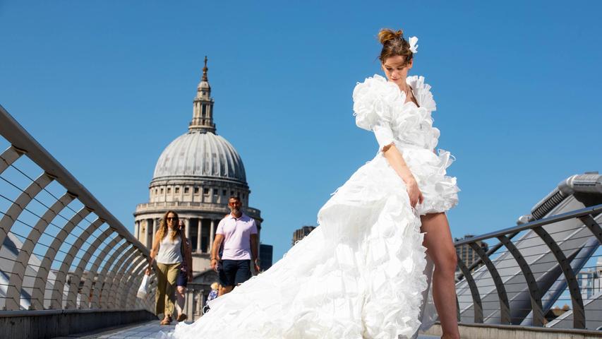 Das Model Jemima Hambro steht auf der Londoner Millennium Bridge in einem von Tom Silverwood entworfenen Hochzeitskleid, das aus über 1500 ungewollten Masken hergestellt wurde. Das Fotoshooting erfolgte für eine Hochzeitsplanungs-Webseite, um die Aufhebung aller Beschränkungen für Hochzeiten in England zu feiern. Trotz dramatisch steigender Infektionszahlen sind in England fast alle Corona-Maßnahmen aufgehoben worden.