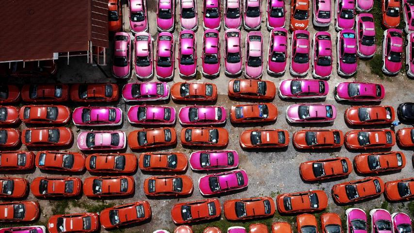 Nein, das ist keine Luftaufnahme von Barbies Fuhrpark, sondern von einer wirtschaftlichen Folge der Corona-Pandemie. Die roten und pinkfarbenen Autos sind geparkte Taxis in Thailands Hauptstadt Bangkok. Ihre Fahrer mussten sie vorübergehend abgeben, weil sie die Fahrzeuge mangels Einnahmen durch den eingebrochenen Tourismus nicht länger mieten konnten. 