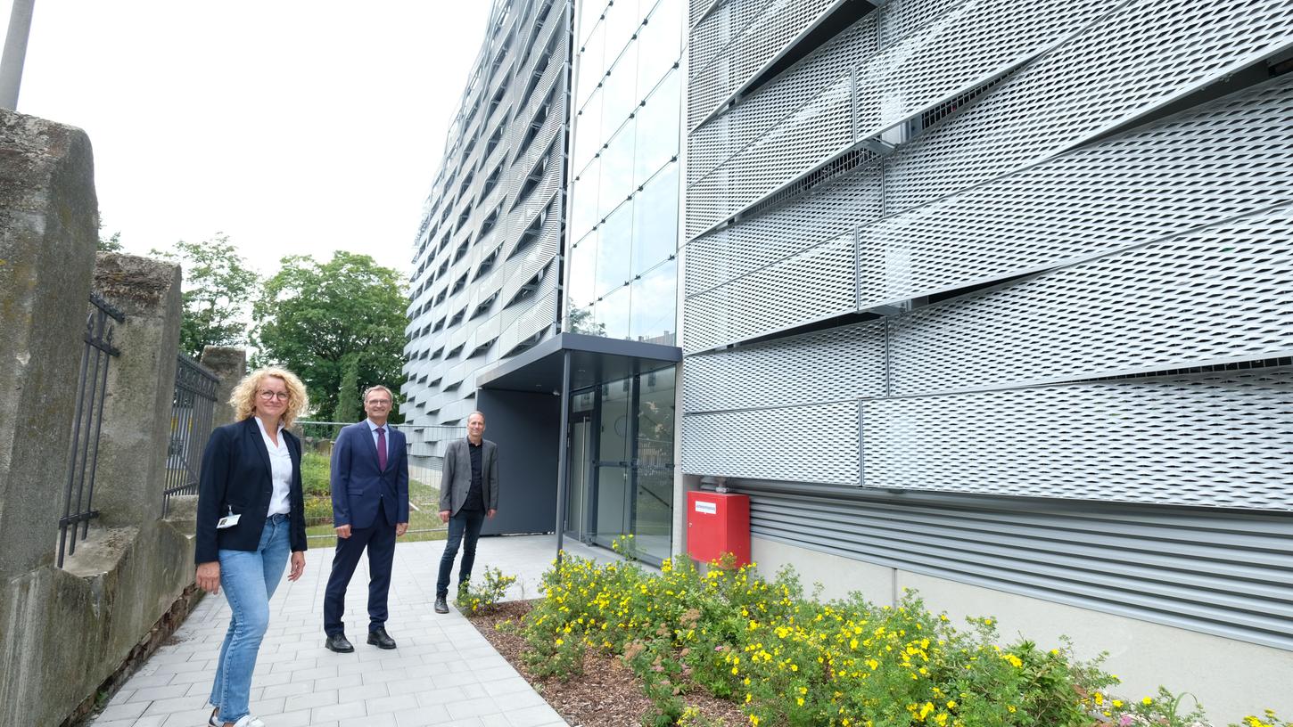 Elisabeth Mathes, Verantwortliche für die Bauausführung, mit N-Ergie-Vorstand Josef Hasler und Hausarchitekt Jochen Stein am Eingang zu dem neuen Parkhaus mit der markanten Lamellen-Fassade. Links der historische Werkszaun, der unter Denkmalschutz steht.
Elisabeth Mathes, Verantwortliche für die Bauausführung, mit N-Ergie-Vorstand Josef Hasler und Hausarchitekt Jochen Stein am Eingang zu dem neuen Parkhaus mit der markanten Lamellen-Fassade. Links der historische Werkszaun, der unter Denkmalschutz steht.