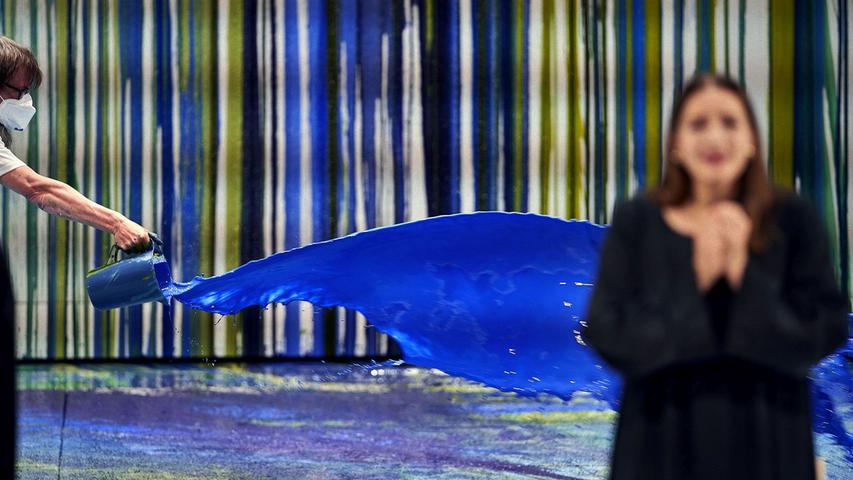 Sieglinde (Lise Davidsen) singt vor einer blauen Farbfontäne.
Sieglinde (Lise Davidsen) singt vor einer blauen Farbfontäne.