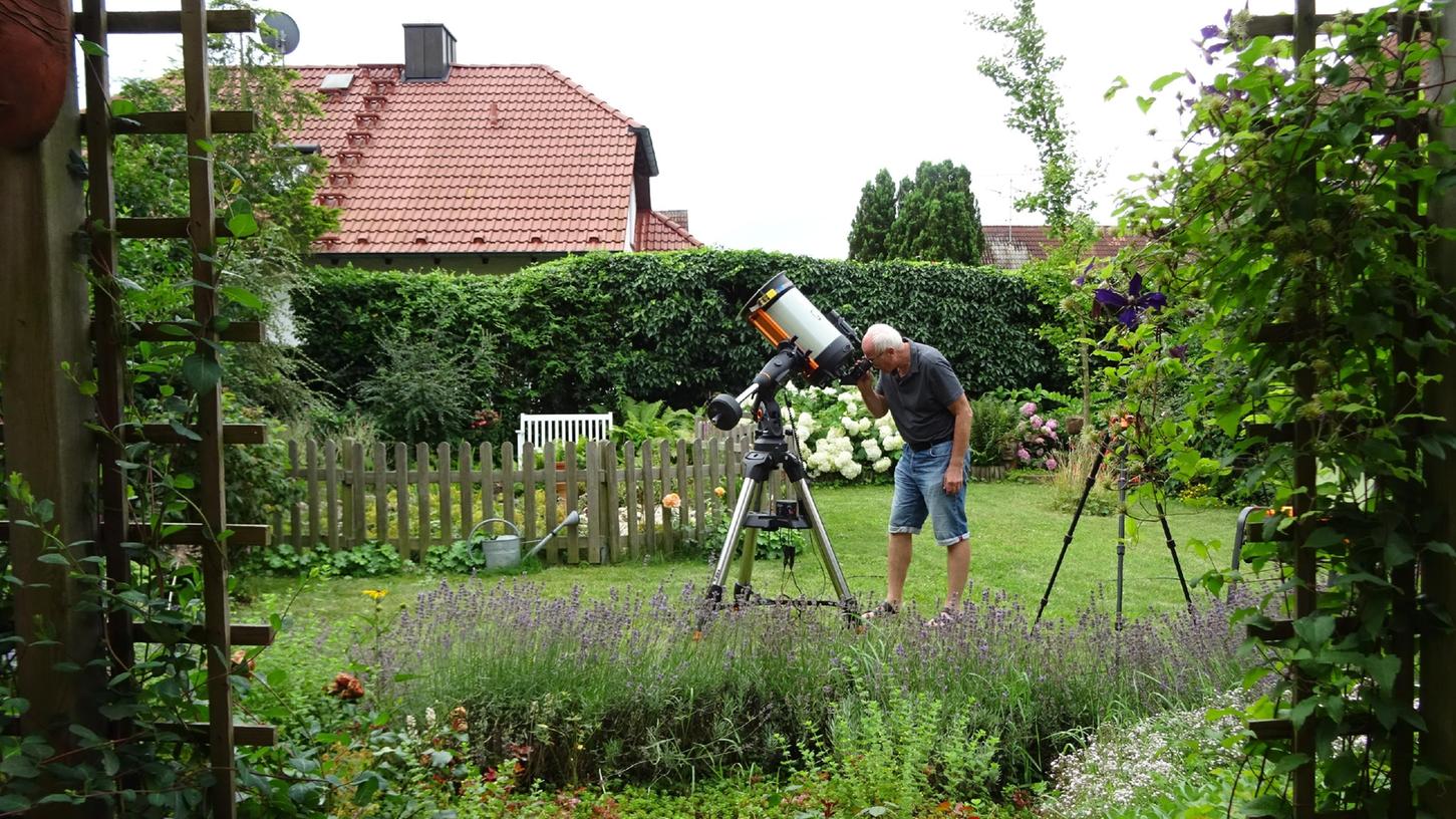 Am Teleskop und auf der kleinen Bank am Gartenteich in seinem eigenen Garten in Weisendorf fühlt sich Reinhard Grimmer wohl.