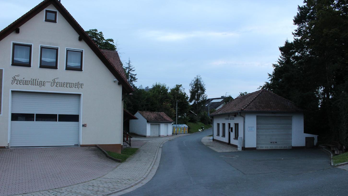 Auf dem Bild sieht man links das Feuerwehrgerätehaus in Untermembach mit Frontansicht, hinten in der Mitte quasi das alte Gerätehaus, das dient aber nur noch als Lagerhalle.