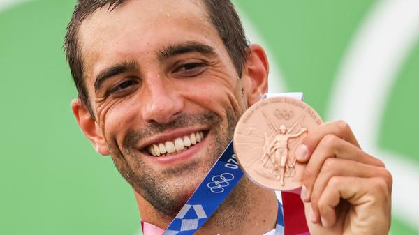 Hannes Aigner aus Deutschland jubelt bei der Siegerehrung mit seiner Bronzemedaille. Der Slalomkanute hat im olympischen Finale in Tokio im Einer-Kajak mit einem fehlerfreien Lauf nur dem neuen Olympiasieger Jiri Prskavec aus Tschechien und Jakub Grigar aus der Slowakei den Vortritt lassen müssen.