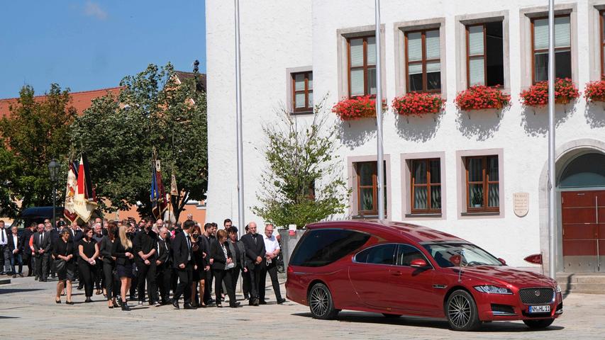 Die Trauergäste schritten hinter dem Leichenwagen am Rathaus vorbei.
Die Trauergäste schritten hinter dem Leichenwagen am Rathaus vorbei.
