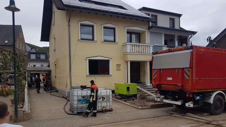 Die Feuerwehrleute aus dem Landkreis Neumarkt pumpen in der Gemeinde Dernau im Landkreis Ahrweiler Heizöl ab.