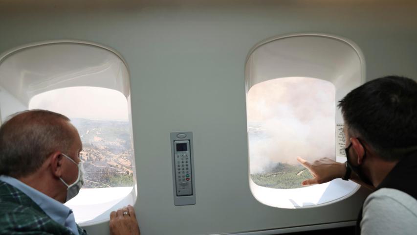 Recep Tayyip Erdogan (l), Präsident der Türkei, und Bekir Pakdemirli, Forstminister der Türkei, sehen sich aus einem Flugzeug das Ausmaß der Waldbrände in der Kreisstadt Manavgat an.