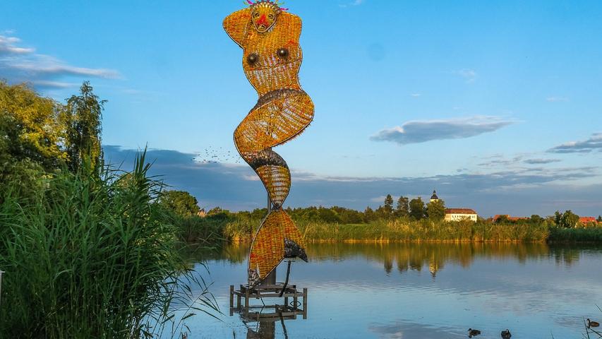 Am Schwemmweiher in Kleingründlach ist die Skulptur "Marilyn, die Meerjungfrau" aus floureszierendem Plexiglas ein Hingucker. Im Hintergrund ist das "Hallerschloss Großgründlach" zu erkennen. 