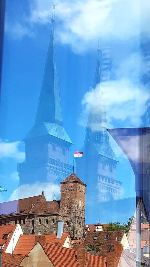 Die Sebalduskirche scheint über der Nürnberger Burg zu schweben. Fotografiert mittels Fensterspiegelung vom Haus Eckstein.