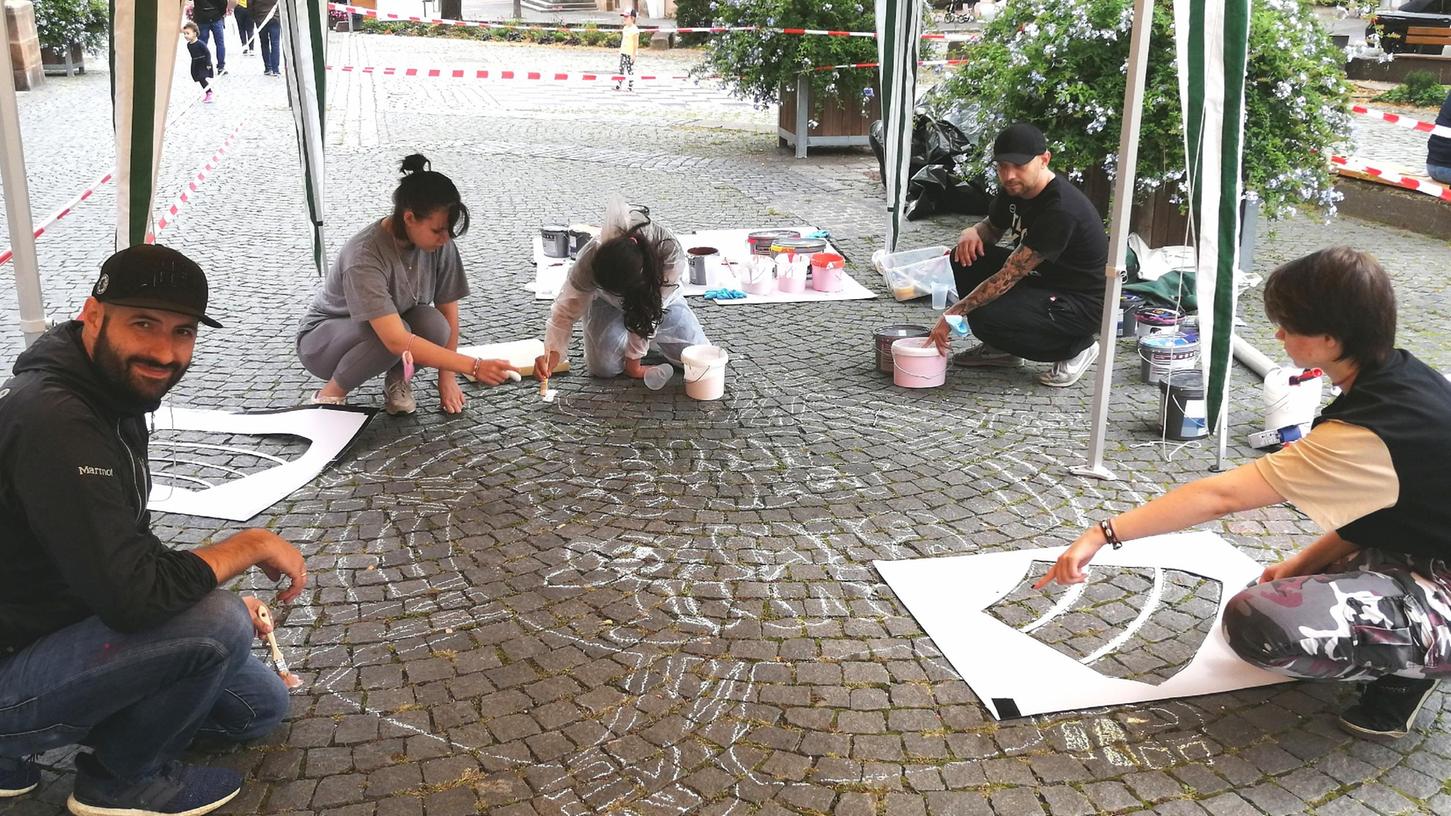 Zusammen mit Carlos Lorente (li.), Künstler und Graffiti-Coach und in diesem Jahr auch bei „Ortung“ mit einer eigenen Arbeit vertreten, gestalteten die Jugendlichen aus dem „Aurex“ ein Streetart-Motiv zum Thema „Diversität“ auf dem Martin-Luther-Platz. 
