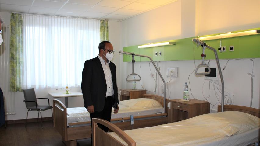 Landrat Manuel Westphal sieht sich in einem der Reha-Zimmer um. Die Vorhänge oder die Pflegebetten in Holzoptik, die weniger nach Krankenhaus aussehen, machen die Zimmer wohnlicher.