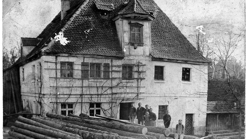 Die Braun‘sche Mühle (Station 12) auf einer Aufnahme von 1913. Die Stämme, die im Bild-Vordergrund liegen, sollen in der Mühle gesägt werden.  