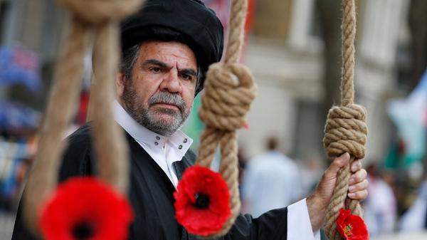 Im Iran wurde ein neuer Präsident gewählt, ein Hardliner. Das Land richtet jährlich unzählige Verurteilte - neben Verbrechern auch Regimegegner - am Galgen hin. Gegen die Amtseinführung protestieren Exiliraner in London mit Blumen in Galgenknoten.