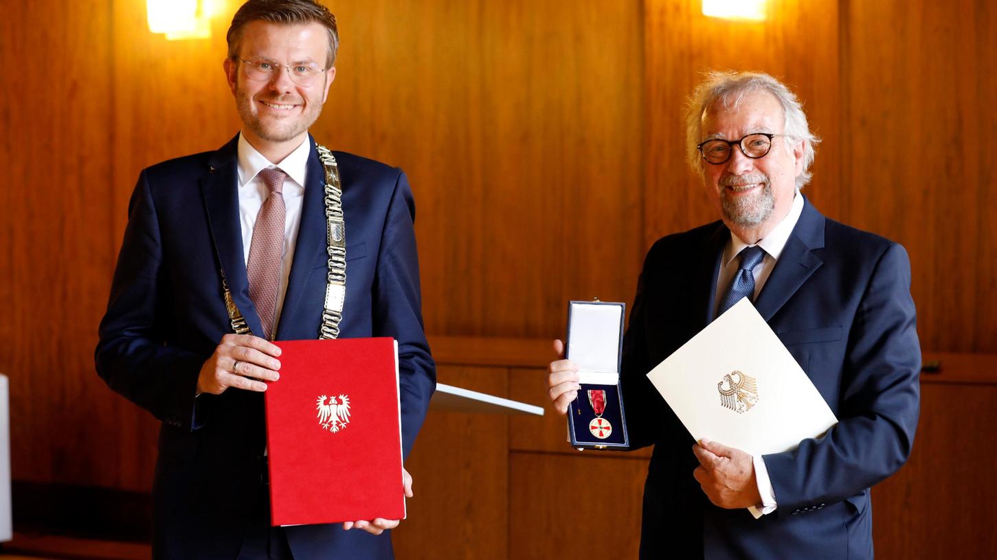 Im Namen von Bundespräsident Frank-Walter Steinmeier überrreichte Nürnbergs Oberbürgermeister Marcus König (CSU) die Verdienstmedaille an Stefan Engeln (rechts).
