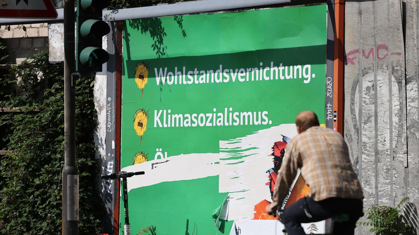 Ein beschädigtes Plakat mit den Schriftzügen "Wohlstandsvernichtung" und "Klimasozialismus" hängt am Straßenrand. Die deutschen Grünen wehren sich vor der Bundestagswahl im September gegen eine massive Anti-Grünen-Wahlkampagne. In verschiedenen Großstädten