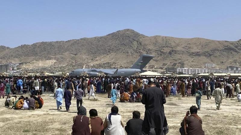 Hunderte Afghanen versammeln sich am Flughafen von Kabul um ein Transportflugzeugs der US-Luftwaffe in der Hoffnung, mit diesem vor den Taliban fliehen zu können.