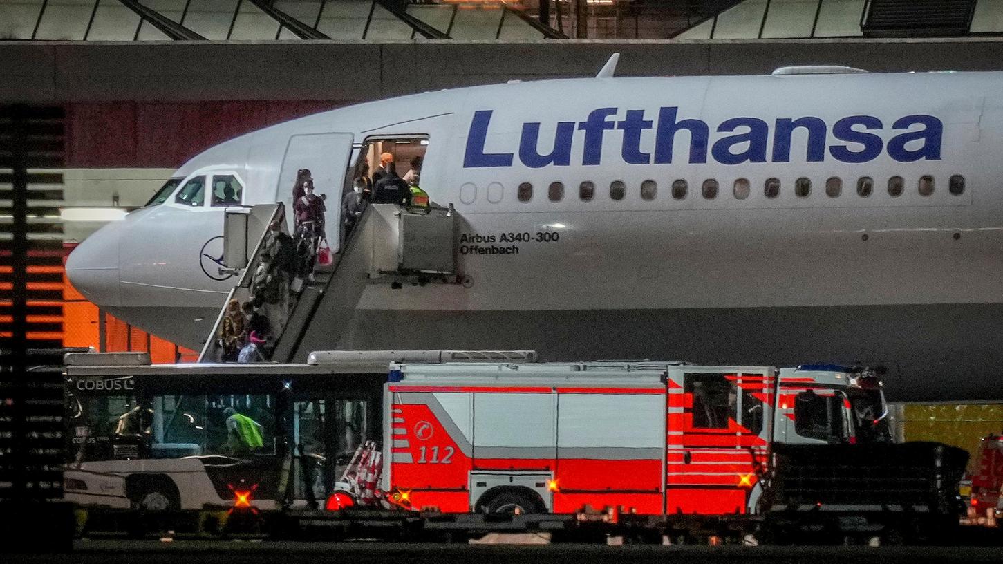 Menschen steigen aus einem Flugzeug der Lufthansa aus, das am Flughafen Frankfurt gelandet ist. Mit dem Flug wurden Menschen aus dem usbekischen Taschkent nach Deutschland gebracht, die zuvor aus Afghanistan evakuiert wurden.