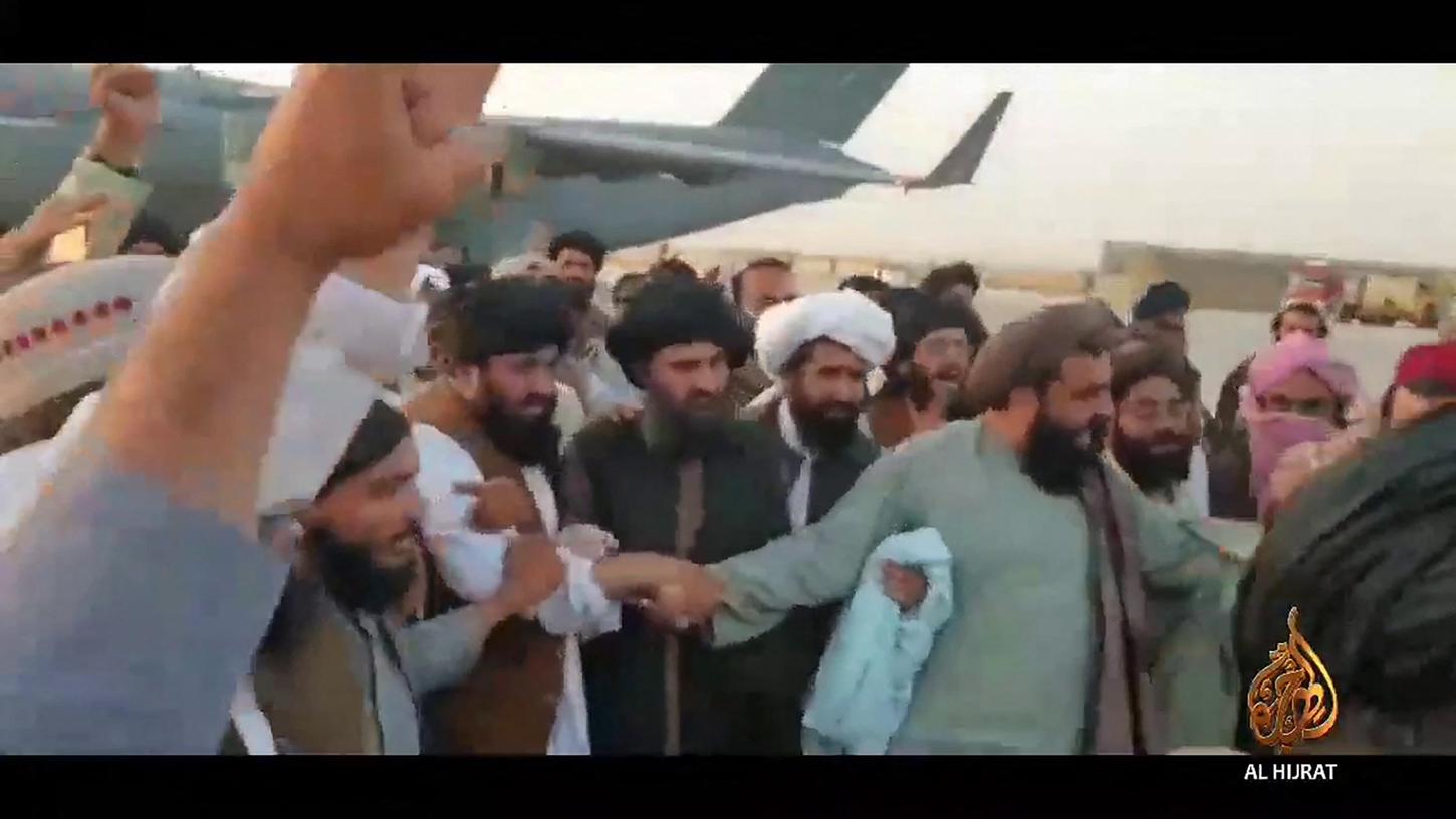 Der Taliban-Anführer Mullah Baradar wird am Flughafen von anderen Islamisten im Empfang genommen.