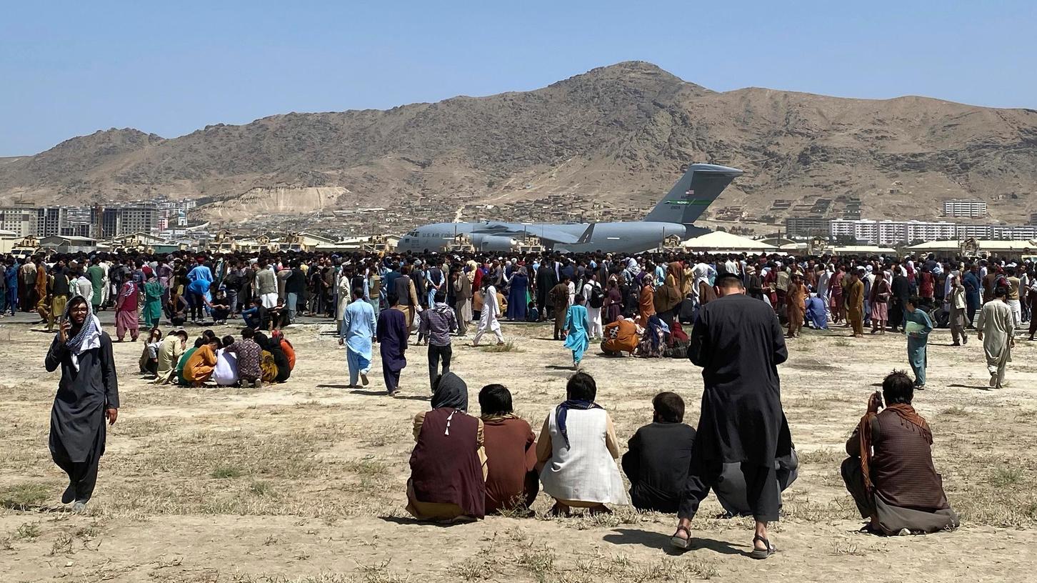Hunderte von Afghanen scharen sich an einer Absperrung vor einem US-Transportflugzeug auf dem internationalen Flughafen in Kabul. Die Lage im Land ist nach wie vor chaotisch. Schon früher geflüchtete Angehörige, insbesondere von Ortskräften der westlichen Alliierten, aber auch ganz generell von Taliban-Kritikern, Frauen und Mädchen, sorgen sich auch in Deutschland um das Schicksal ihrer Familien.  