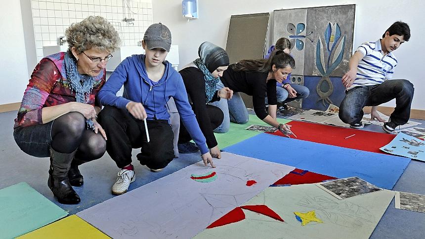 Unter Aufsicht von Lehrerin Jutta Bär (li.) und Künstlerin Manuela Dilly (3. v. re.) zeichnen die Schüler Motive auf bunte Bauplatten, die später eingespachtelt werden. Das letzte Sgrafitto-Teilstück (hinten) vom alten Schulhaus ist bereits restauriert. Unter Aufsicht von Lehrerin Jutta Bär (li.) und Künstlerin Manuela Dilly (3. v. re.) zeichnen die Schüler Motive auf bunte Bauplatten, die später eingespachtelt werden. Das letzte Sgrafitto-Teilstück (hinten) vom alten Schulhaus ist bereits restauriert.