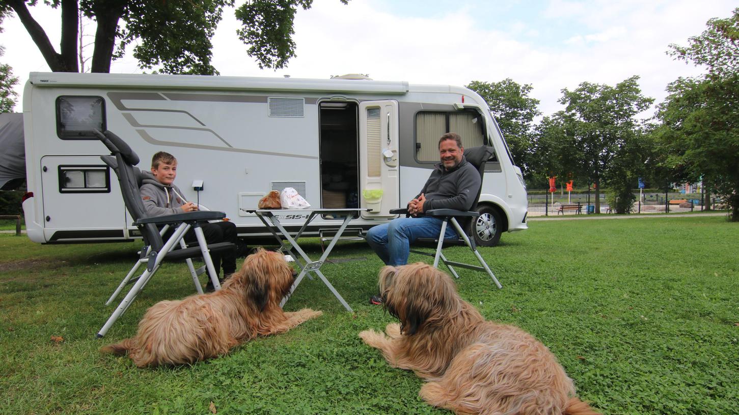 Rainer Lorenz und sein Sohn Finn machen es sich mit Aria und Paule vor dem eigenen Wohnmobil am Campingplatz am Freibad gemütlich. 