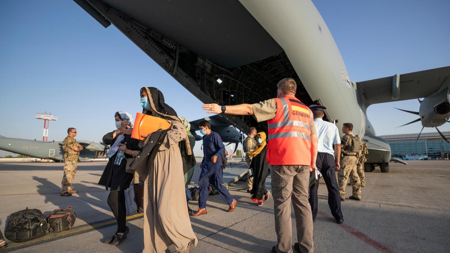 Schutzbedürftige Menschen betreten kurz nach dem Flug aus Kabul sicheren Boden zum Weiterflug nach Deutschland. Aus Afghanistan geflüchtete Personen werden nun doch nicht vorübergehend auf dem US-Truppenübungsplatz in Grafenwöhr untergebracht, die dort errichteten Notunterkünfte werden derzeit nicht benötigt. Schutzbedürftige Menschen betreten kurz nach dem Flug aus Kabul sicheren Boden zum Weiterflug nach Deutschland. Aus Afghanistan geflüchtete Personen werden nun doch nicht vorübergehend auf dem US-Truppenübungsplatz in Grafenwöhr untergebracht, die dort errichteten Notunterkünfte werden derzeit nicht benötigt.