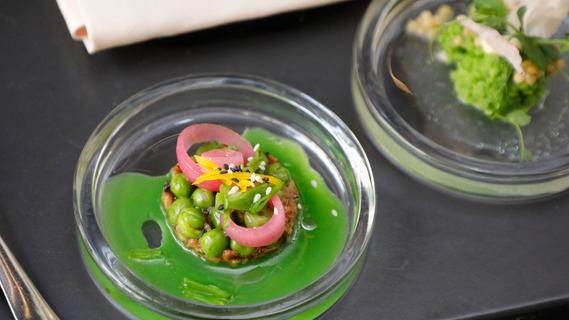 Leuchtend grünes Kunstwerk: Erbsensalat mit Shitake-Pilzen, Sesam und gepickelten Zwiebeln. 