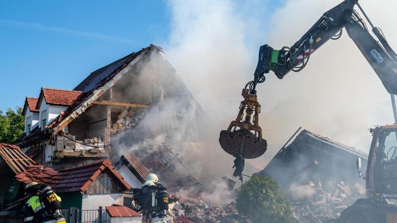 Ein Bagger räumt Teile des eingestürzten Hauses weg. Ein Bagger räumt Teile des eingestürzten Hauses weg.