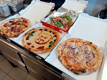 Pizzen mit Gesichtern können vor Ort auch bestellt werden.