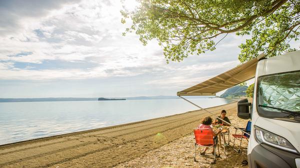 Die Markise ist ein Punkt für sich. Wer den Stellplatz zu Fuß verlässt, etwa für einen Tag am Strand oder einen Abend in der Stadt, sollte sie einrollen. Kommt Wind auf, könnte er die Stützträger verbiegen oder schlimmstenfalls die Markise abreißen, die Reparatur ist kostspielig. Und wer vor dem Einrollen vergisst, Laub und Nadeln abzukehren, muss mit hässlichen Flecken rechnen.