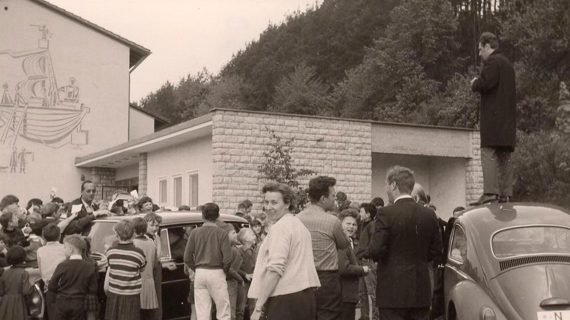 NN-Reporter Rudolf Kroack steht auf dem Autodach und fotografiert Max Merkel bei seiner Autogrammstunde in Unterleinleiter.
NN-Reporter Rudolf Kroack steht auf dem Autodach und fotografiert Max Merkel bei seiner Autogrammstunde in Unterleinleiter.