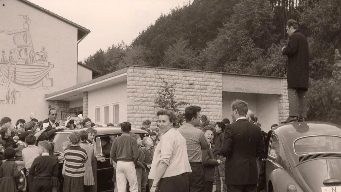 NN-Reporter Rudolf Kroack steht auf dem Autodach und fotografiert Max Merkel bei seiner Autogrammstunde in Unterleinleiter. 