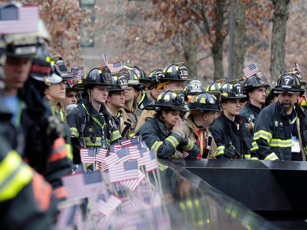 Eine Feuerwehrfrau (M) spricht ein Gebet neben anderen Feuerwehrleuten aus der ganzen Welt während einer Schweigeminute für ihre gefallenen Kameraden am 9/11 Memorial Reflecting Pool vor dem Start des 2nd Annual New York City Firefighter Stair Climb im 4 World Trade Center. Ein Archivbild aus 2016.