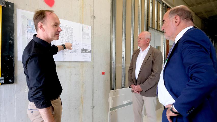 Architekt Hans Jürgen Distler erläutert Landrat Willibald Gailler und Wilhelm Baur, dem Vorsitzenden des Lebenshilfe-Vereins, die Anordnung der Räume im neuen Gebäude.