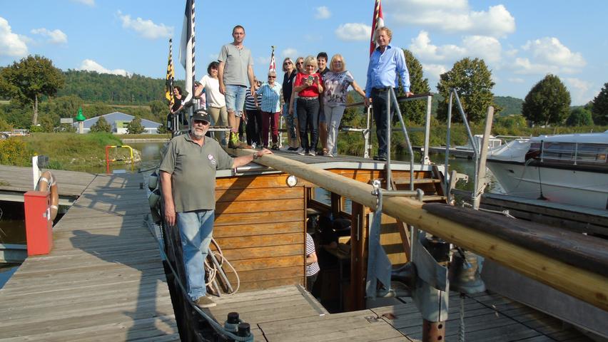Links steht Kapitän Ulrich Burst und oben auf dem Schiff die Vorsitzenden des Jachtclub Berching, Dominik Scholl und Ralf Vaters.