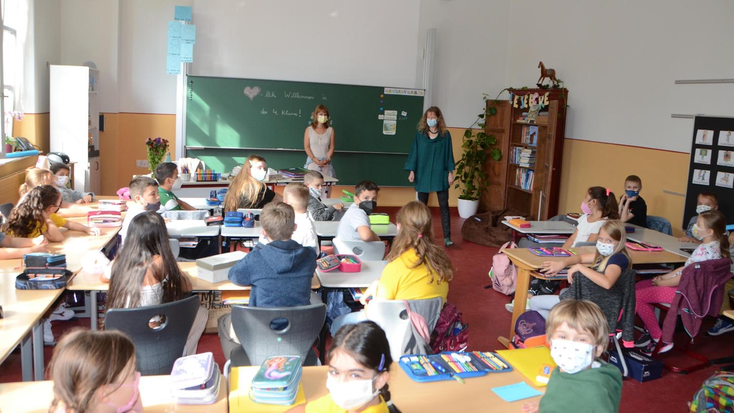 Unterrichtsstart in den sanierten Klassenzimmern der Schwabacher Luitpoldschule. Neu sind etwa die Wandfarben: Lichtgrau und Ocker, getrennt durch ein rotes Band. Rektorin Silke Blomeyer (vorne rechts) gefällt besonders der restaurierte Wandschrank rechts neben der Tafel.