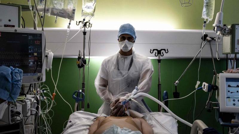 Ein medizinischer Angestellter (M) kümmert sich auf der Intensivstation eines Krankenhauses in Pierre-Benite um einen Corona-Patienten. Ein medizinischer Angestellter (M) kümmert sich auf der Intensivstation eines Krankenhauses in Pierre-Benite um einen Corona-Patienten.