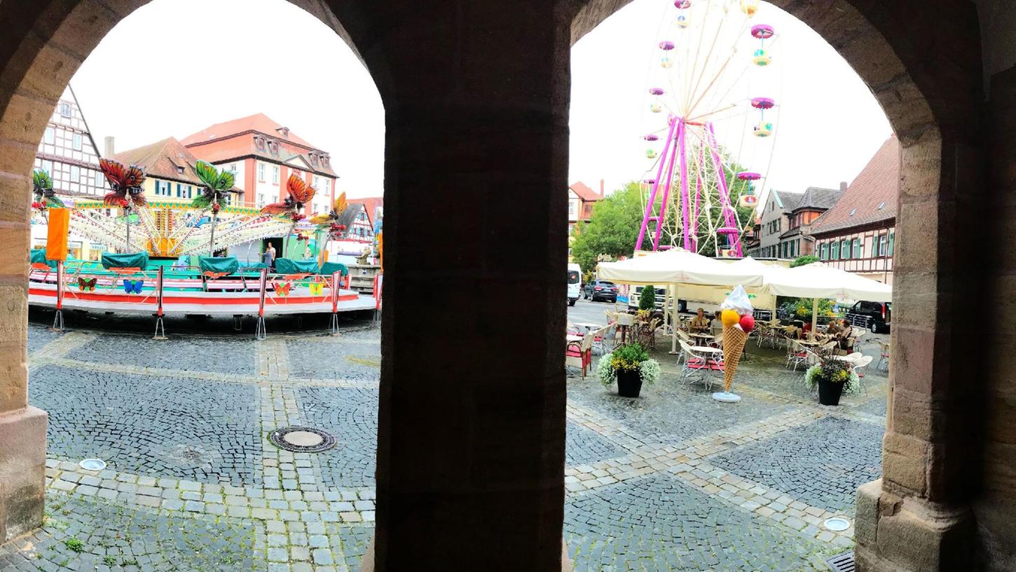 Blick durch die Rathaus-Arkaden auf die Fahrgeschäfte. Das markante Riesenrad steht schon.