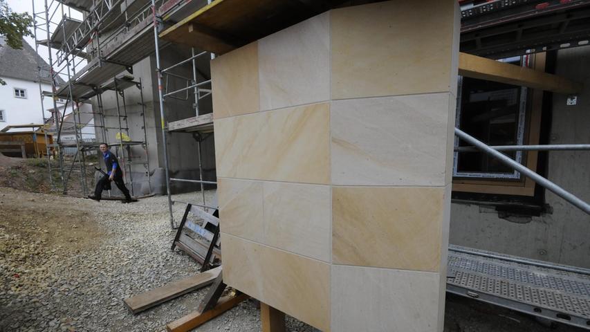 Eine Kostprobe der Sandsteinfassade steht schon auf der Baustelle.
