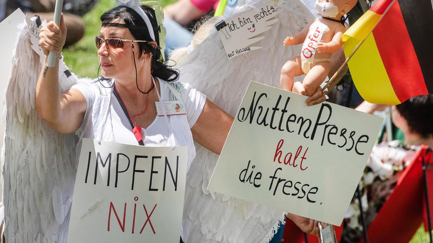 "Impfen Nix Gut" und "Nutten Presse halt die fresse" steht auf dem Schild einer Demonstrantin, die an einer "Querdenker"-Demonstration teilnimmt.